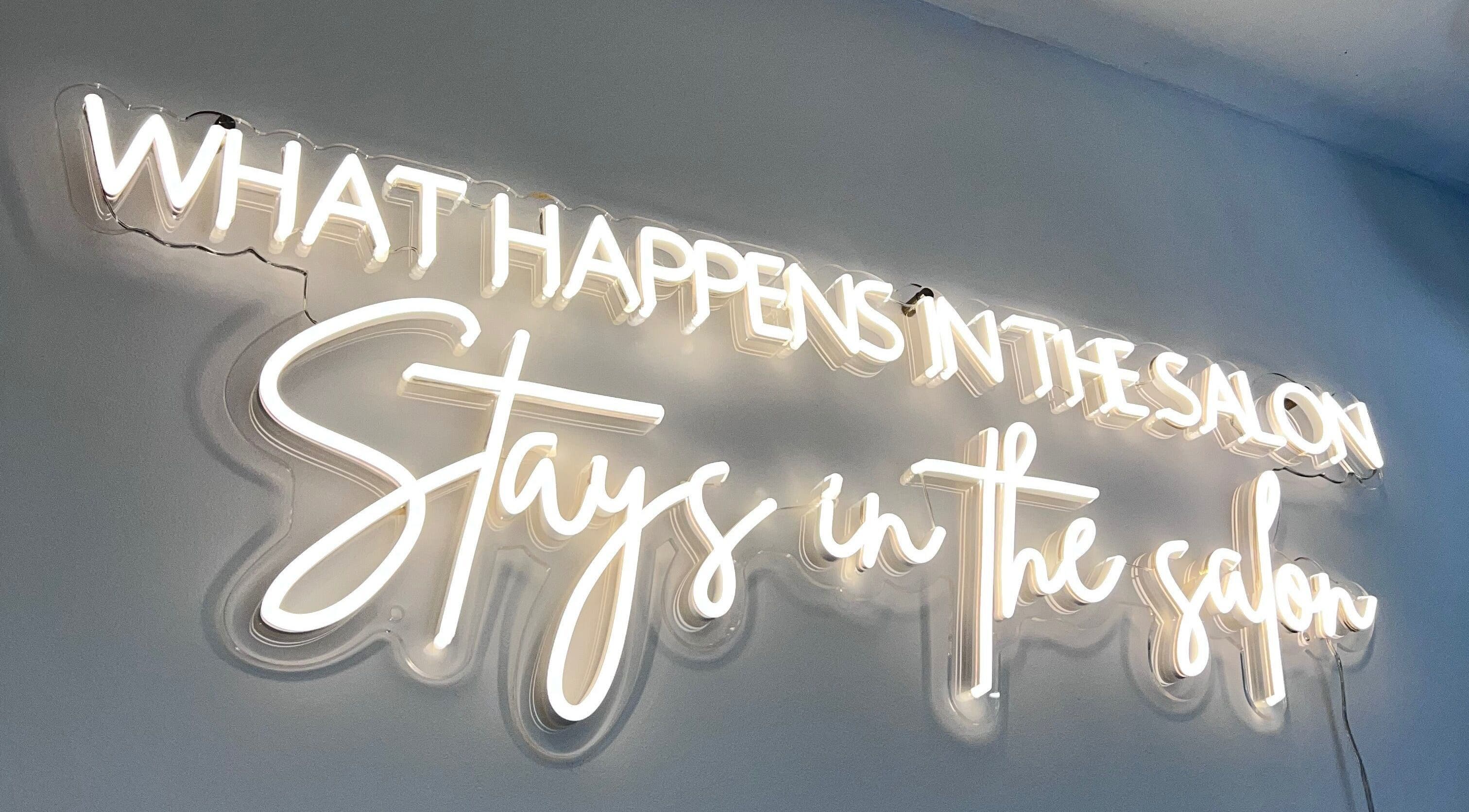 Neon sign at Infinity Hair in Littleport, England, GB saying 'What Happens in the Salon Stays in the Salon'.