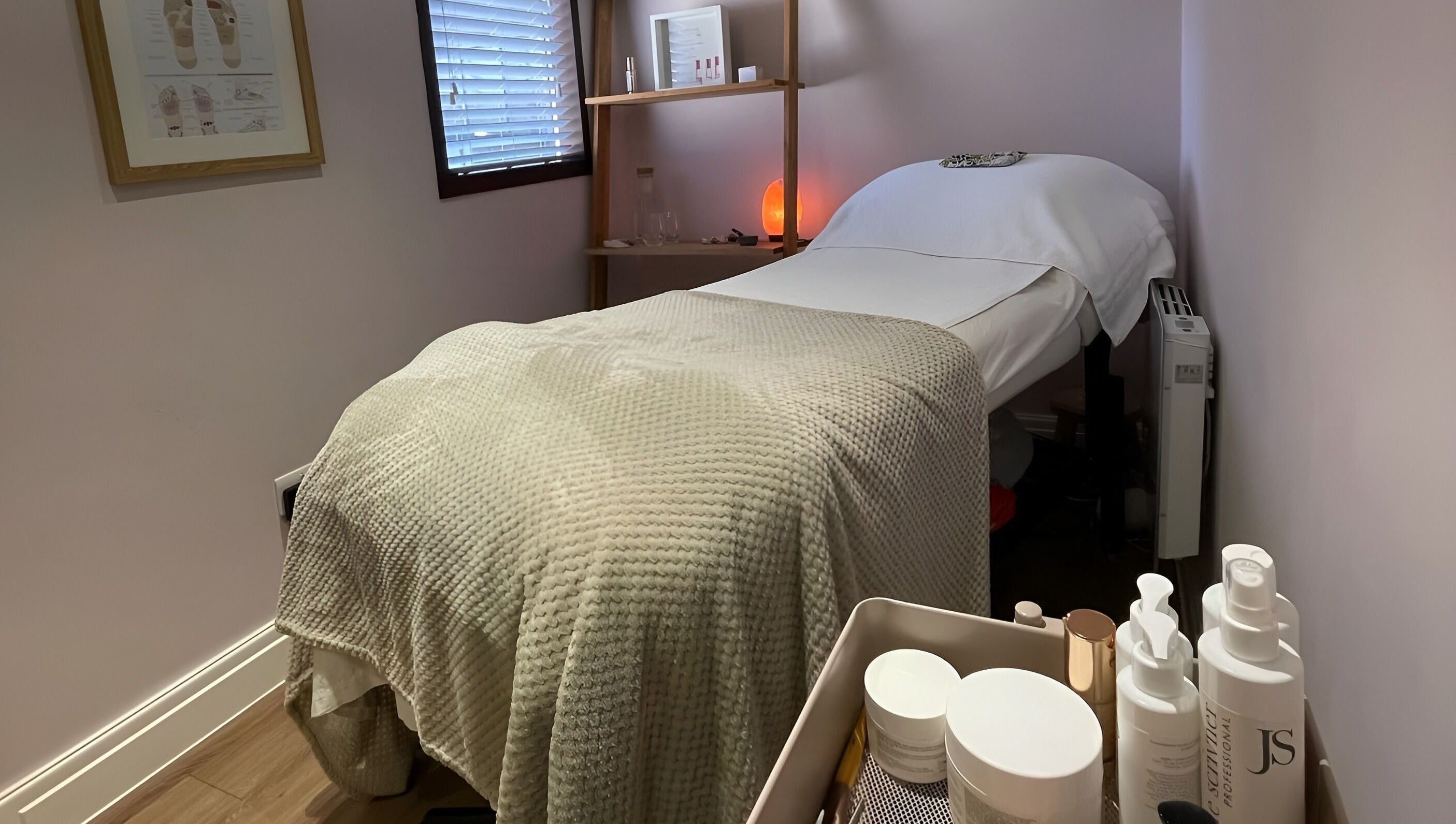 Cozy treatment room at Living Well Reflexology, Mickleton, England, GB, featuring a massage bed and soothing decor.