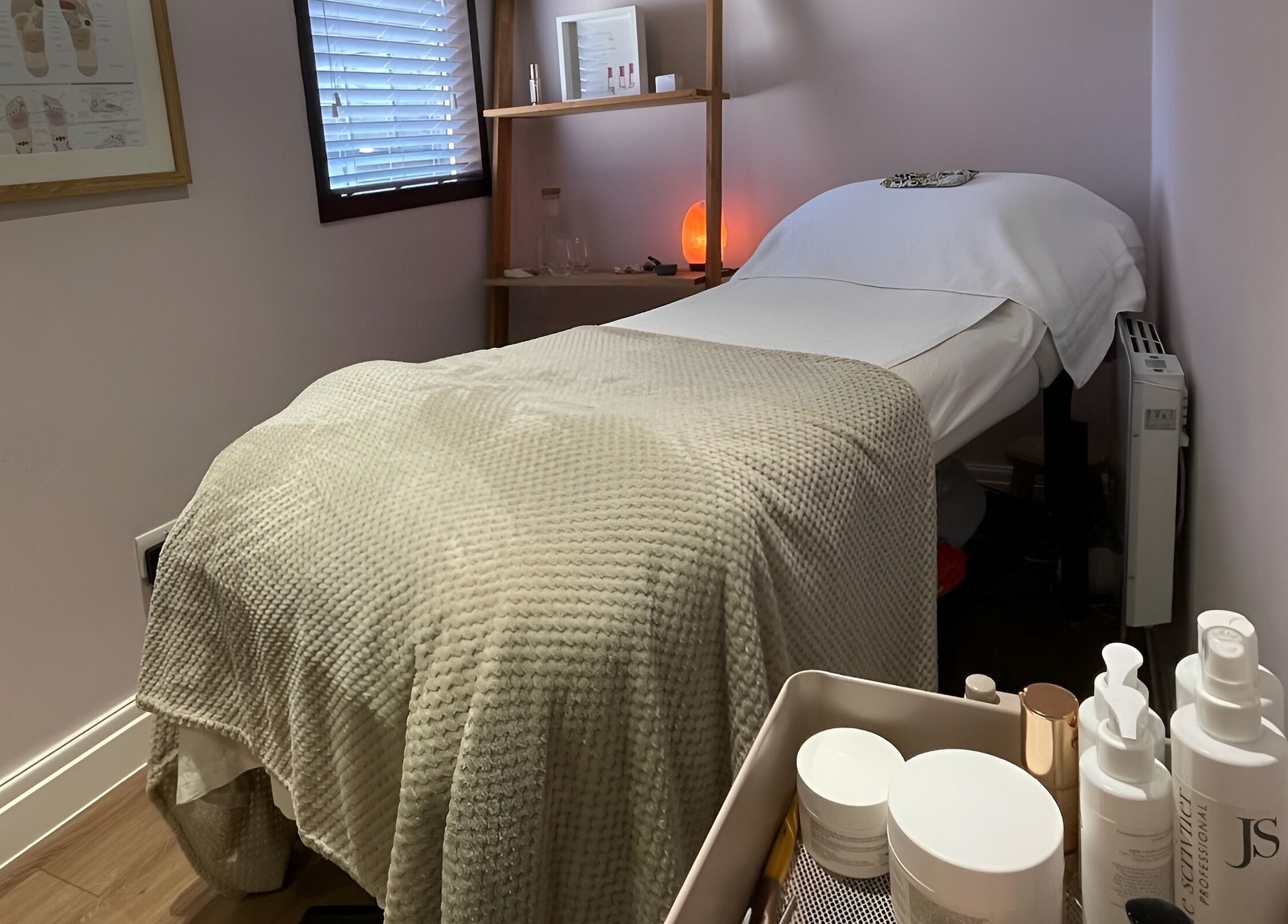 Cozy treatment room at Living Well Reflexology, Mickleton, England, GB, featuring a massage bed and soothing decor.