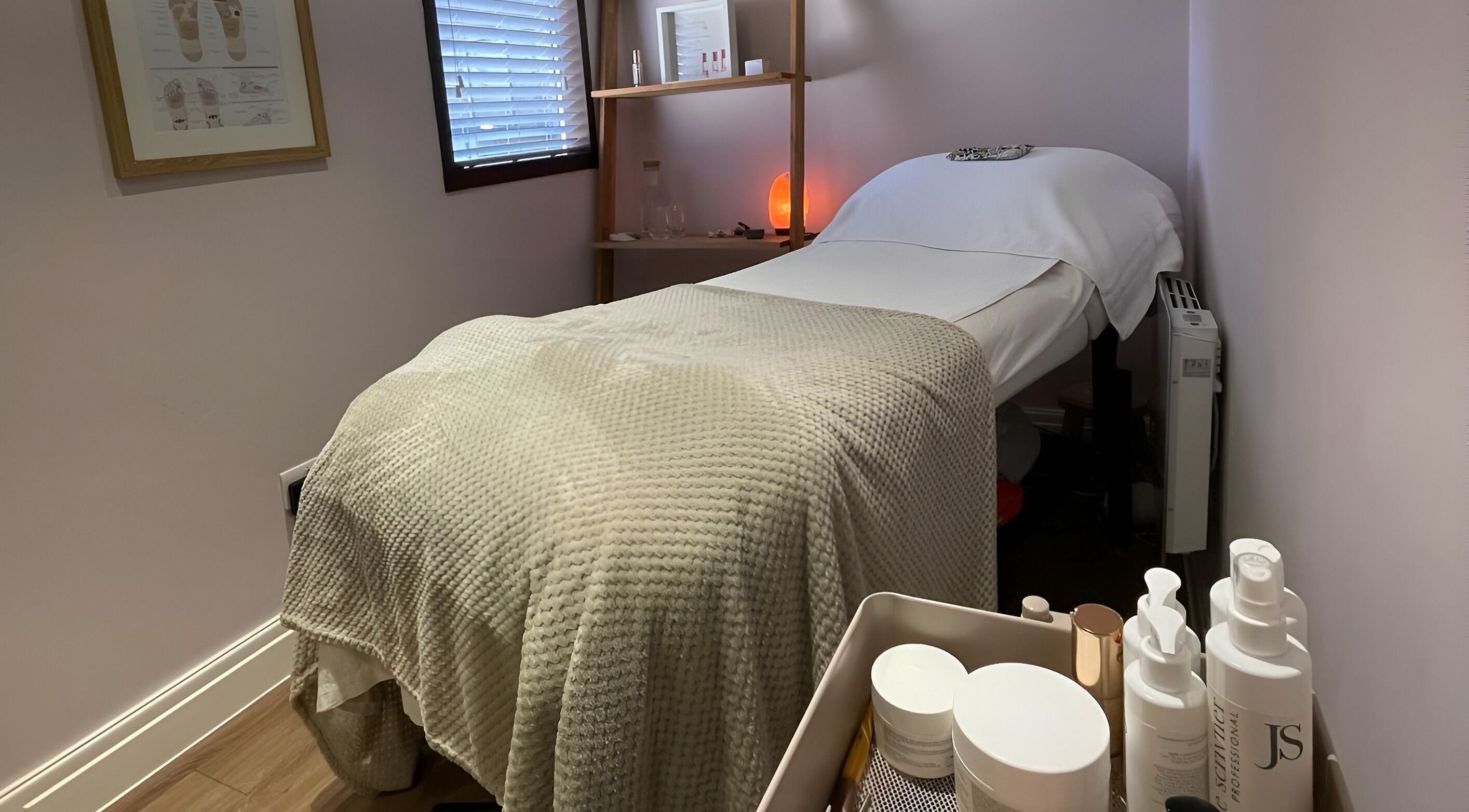 Cozy treatment room at Living Well Reflexology, Mickleton, England, GB, featuring a massage bed and soothing decor.