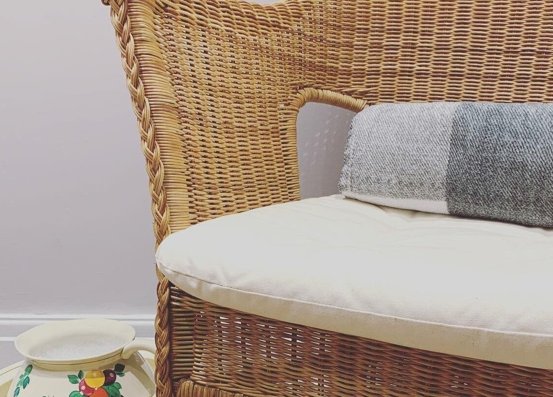 Wicker chair with cushion at Living Well Reflexology, Mickleton, England, GB. Relaxing wellness ambiance.
