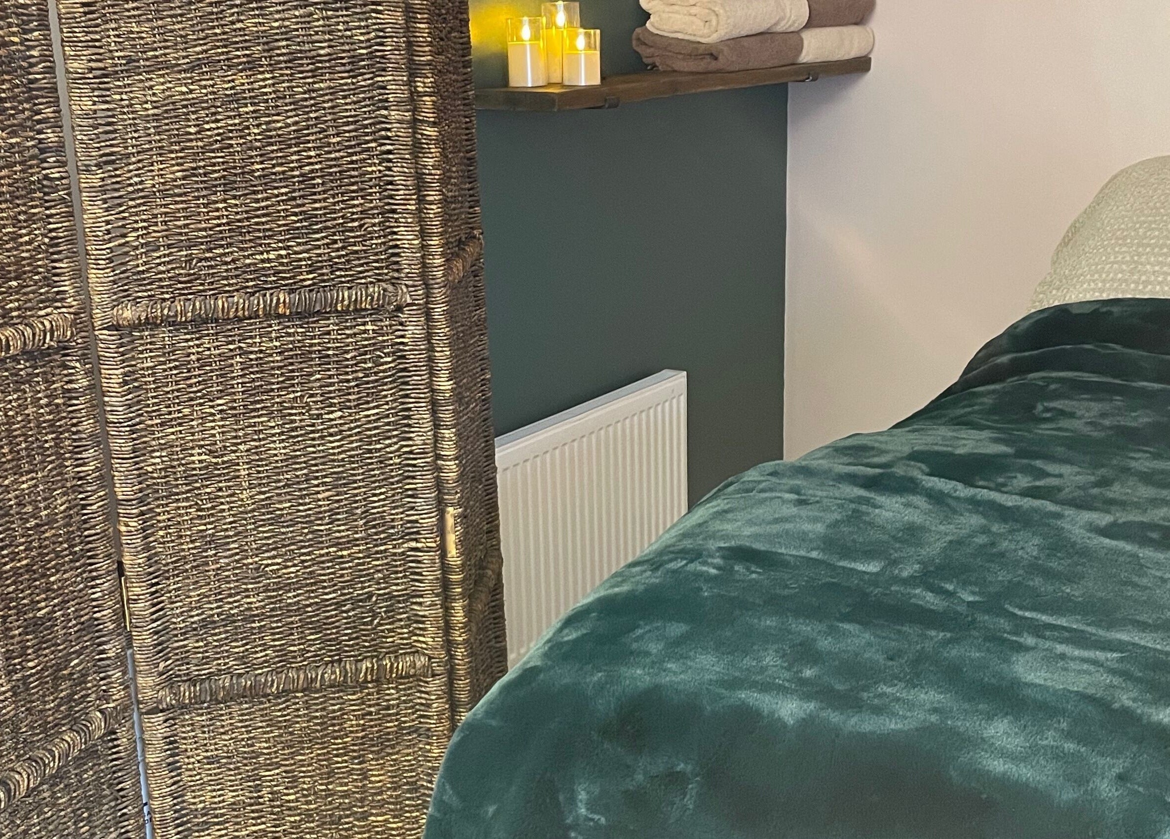 Relaxing treatment room at Living Well Reflexology, Mickleton, England, GB, featuring soft blankets and candles.