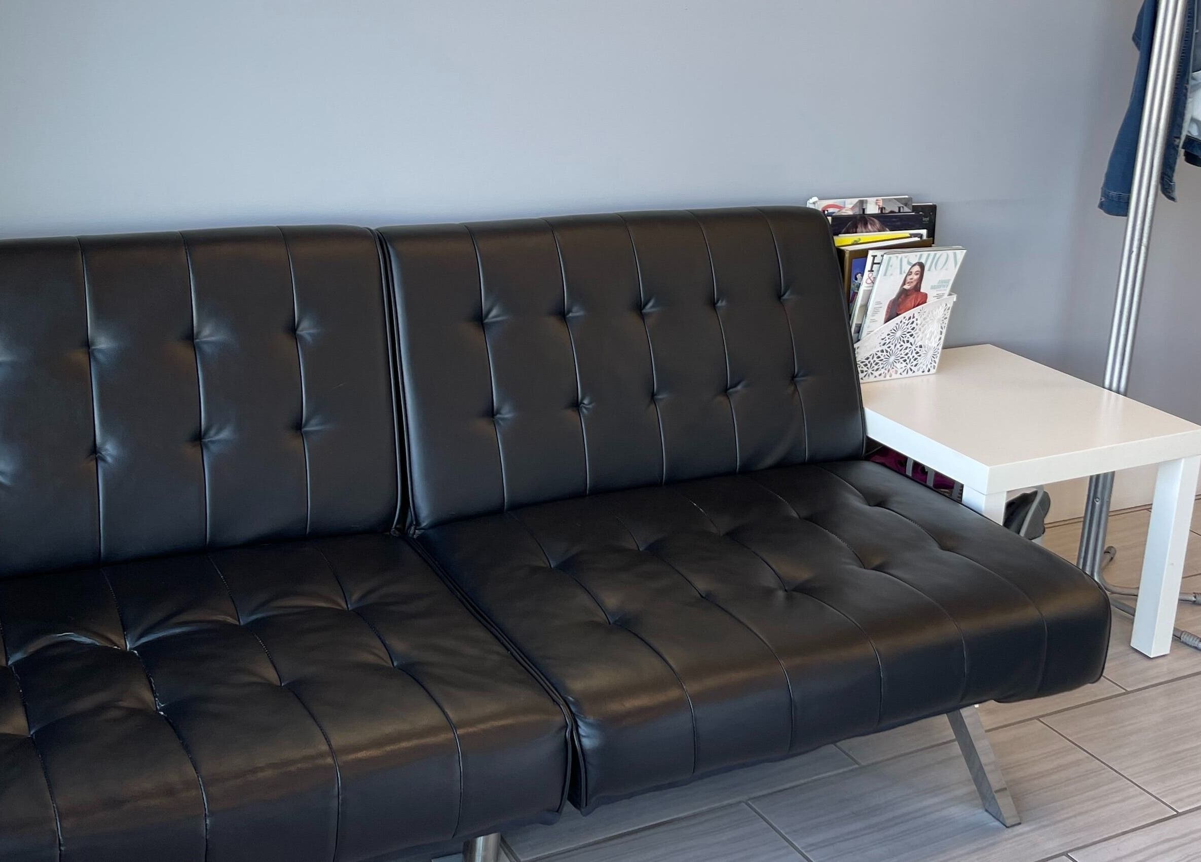 Cozy chic lounge area at Si Salon and Spa, Edmonton, Alberta, CA with modern black leather seating.