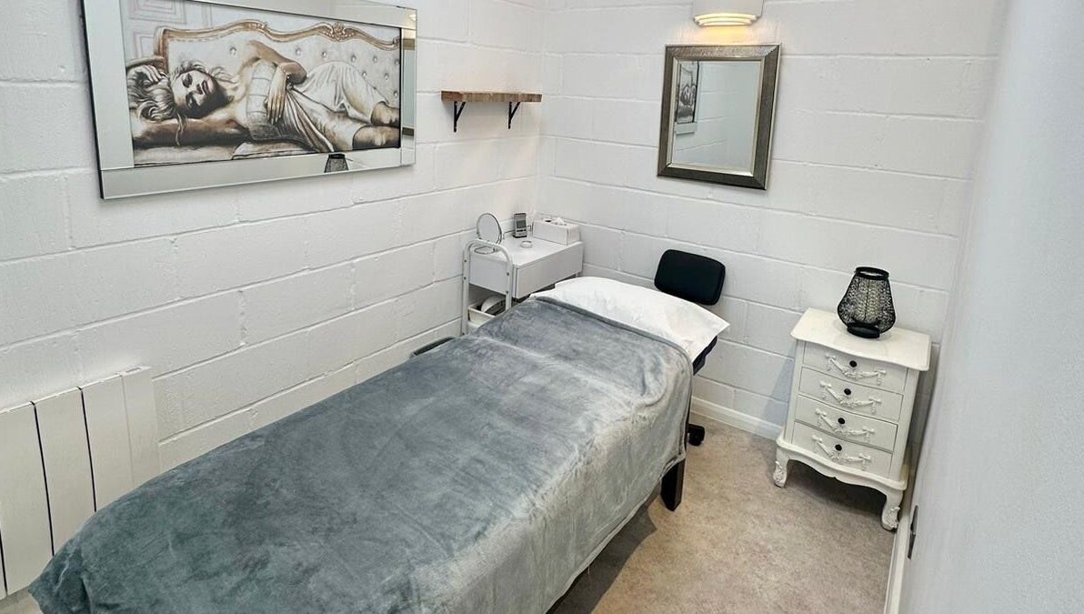 Serene treatment room at Facial Attraction, London, England, GB with a cozy bed and elegant decor.