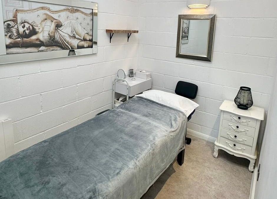 Serene treatment room at Facial Attraction, London, England, GB with a cozy bed and elegant decor.