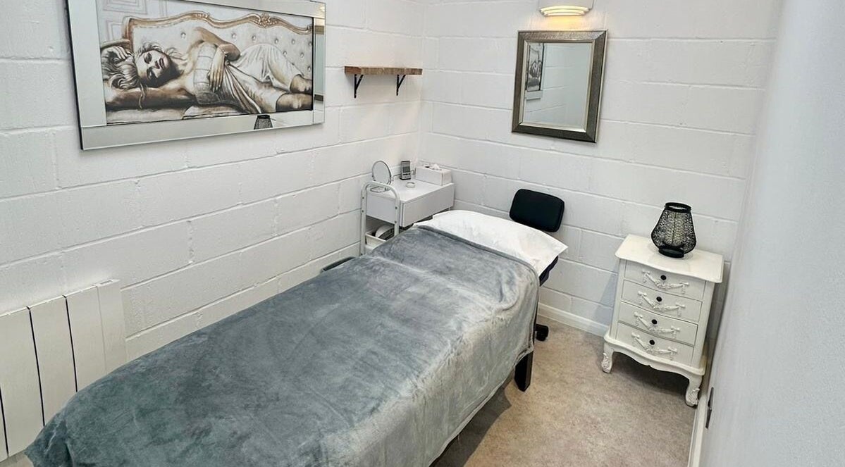 Serene treatment room at Facial Attraction, London, England, GB with a cozy bed and elegant decor.