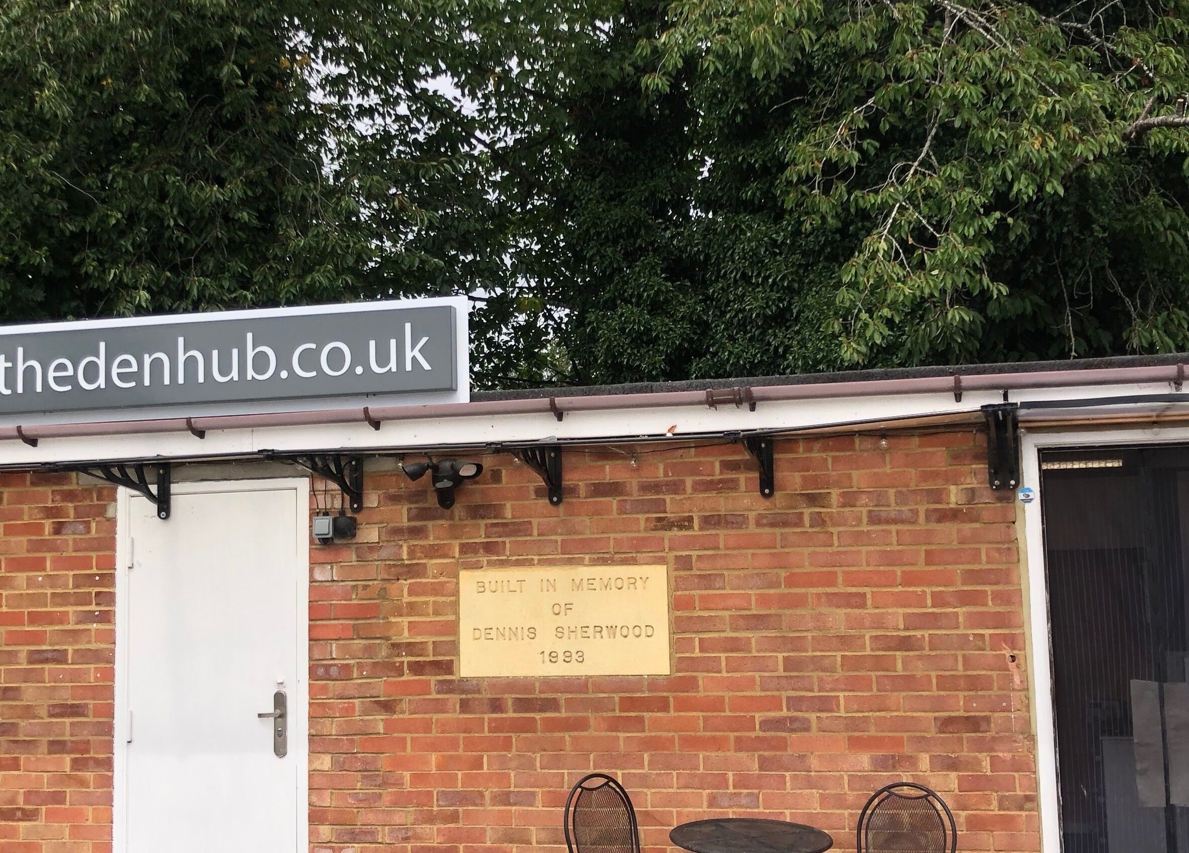 The Beauty Den entrance in Baldock, England, GB with a charming brick facade and greenery.