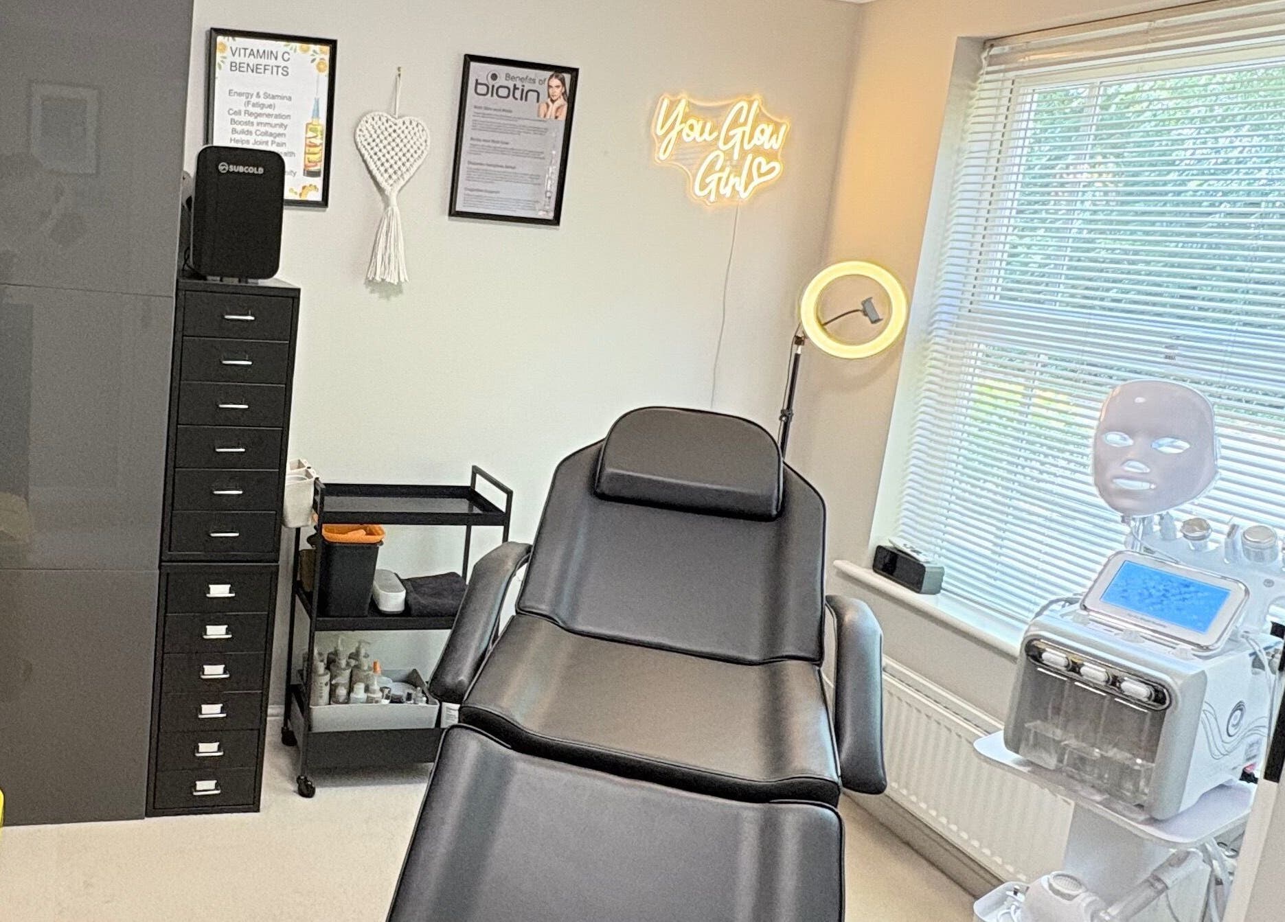 Skinfinity+ luxurious treatment room in Wokingham, England, GB, featuring a modern therapy chair and neon sign.