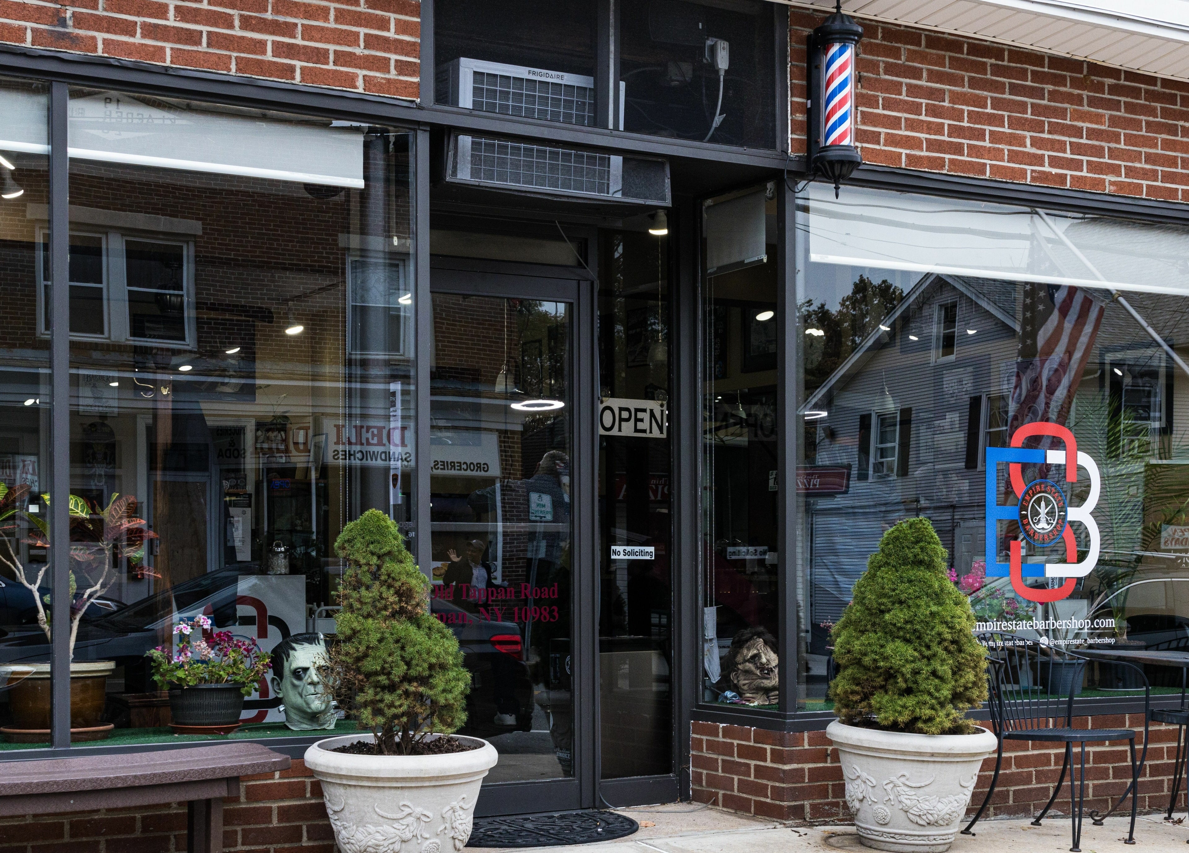 Exterior view of Empire State Barbershop, located in Tappan, New York, US. Inviting entrance with modern signage.