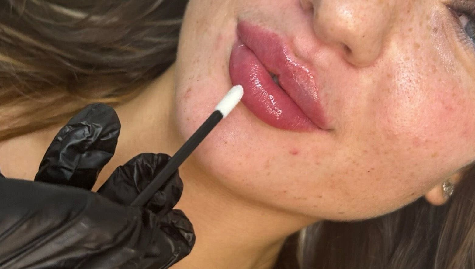 Professional lip gloss application at The Beauty Clinic in Bedford, England, GB, enhancing natural beauty.