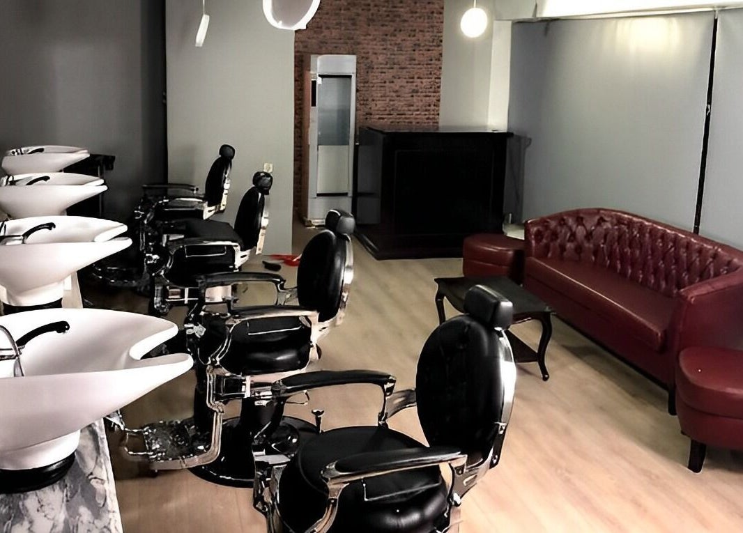 Interior sofisticado da Barbearia Dom Cortês em Porto, Porto, PT, com cadeiras de couro e ambiente acolhedor.