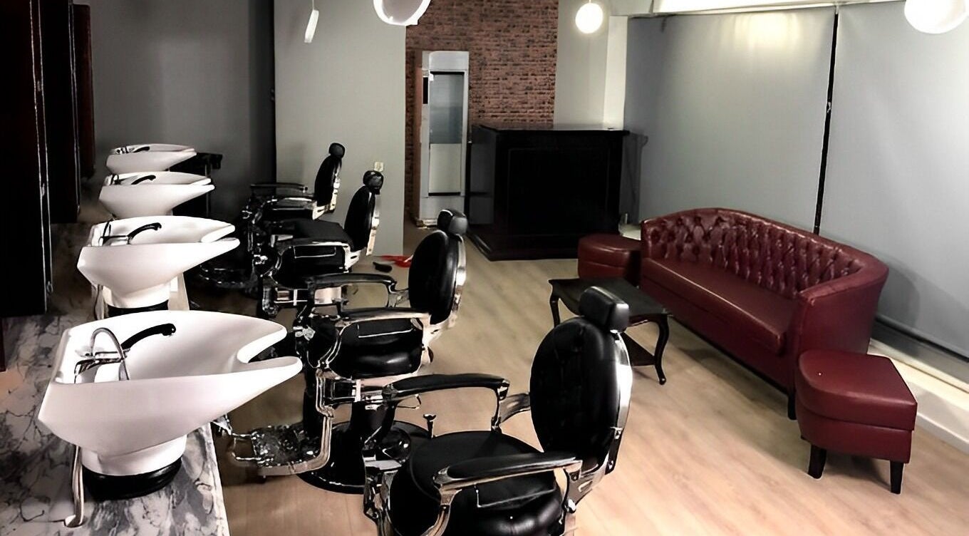 Interior sofisticado da Barbearia Dom Cortês em Porto, Porto, PT, com cadeiras de couro e ambiente acolhedor.
