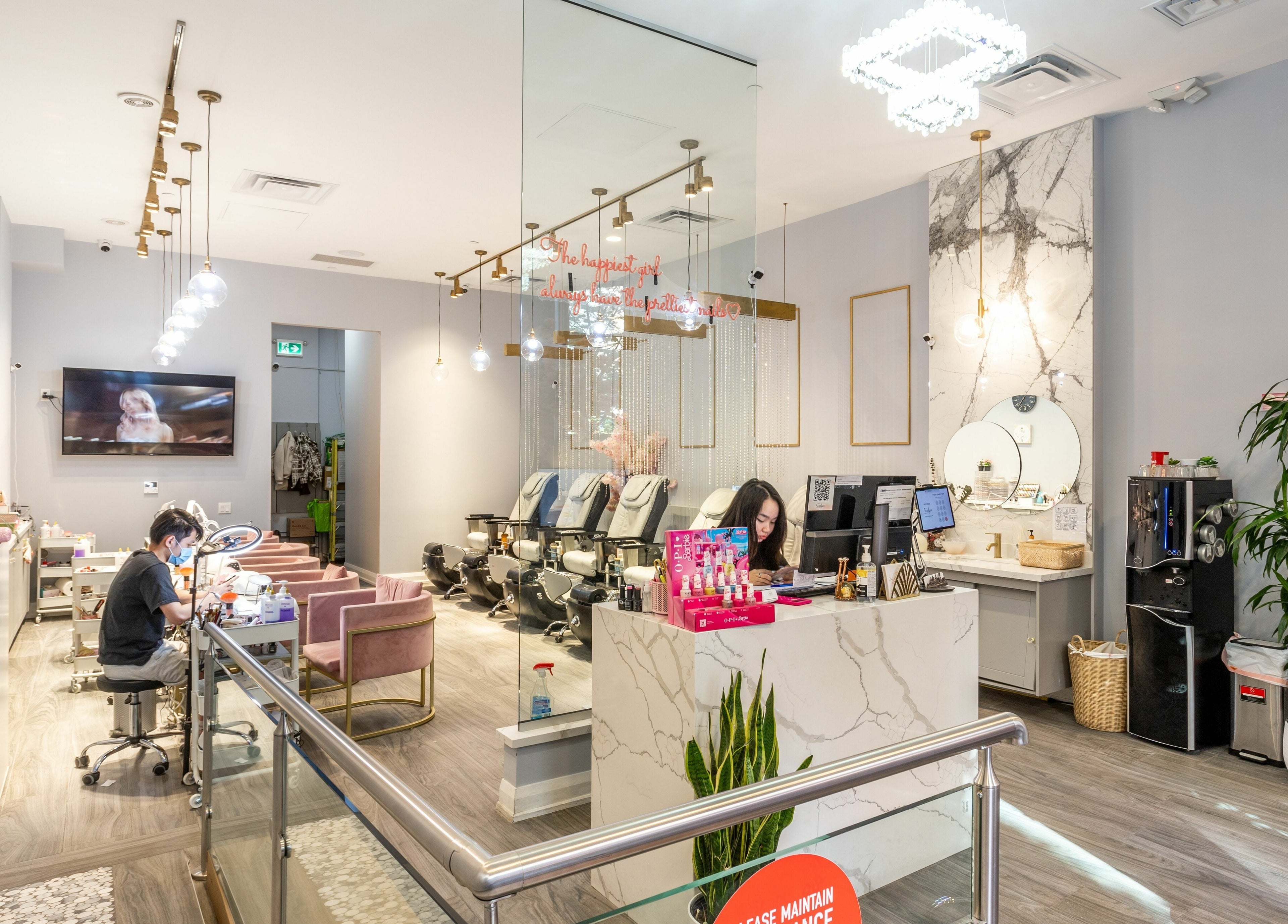Interior of Tokyo Nails and Spa, Toronto, Ontario, CA, showing chic decor and a nail technician at work.