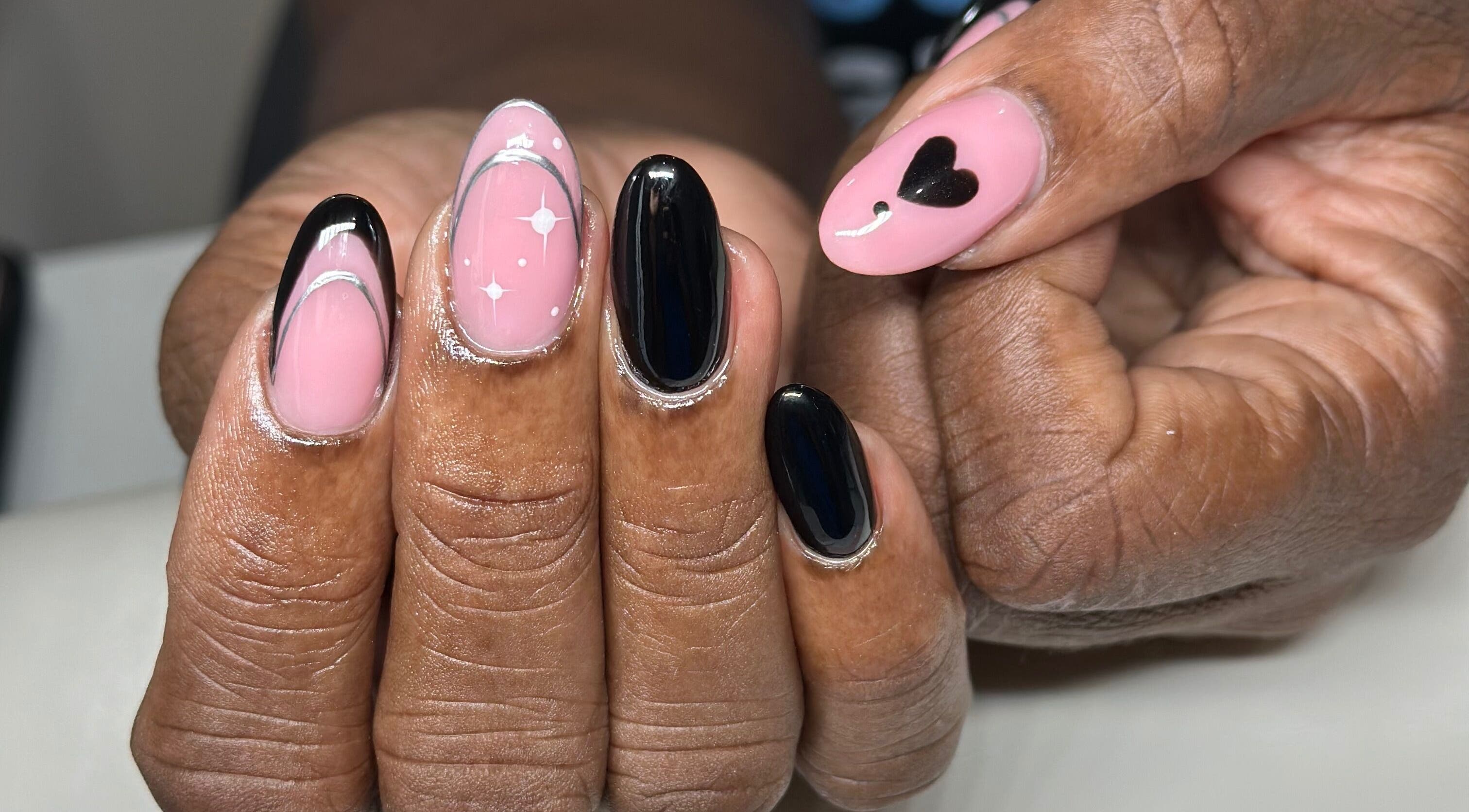 Nhanced in Bridgetown, Saint Thomas, BB features intricate black and pink nail art with heart and star designs.
