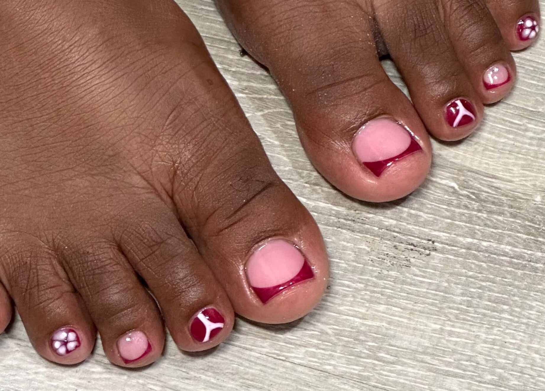 Stylish toenail art at Nhanced, Bridgetown, Saint Thomas, BB includes intricate red and pink designs.