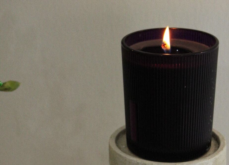 Lit candle in a dark holder at Silkmuse Laser & Skin, Uddingston, Scotland, GB creating a calming ambiance.