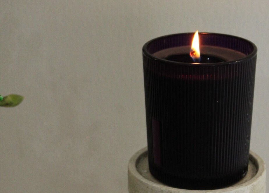 Lit candle in a dark holder at Silkmuse Laser & Skin, Uddingston, Scotland, GB creating a calming ambiance.