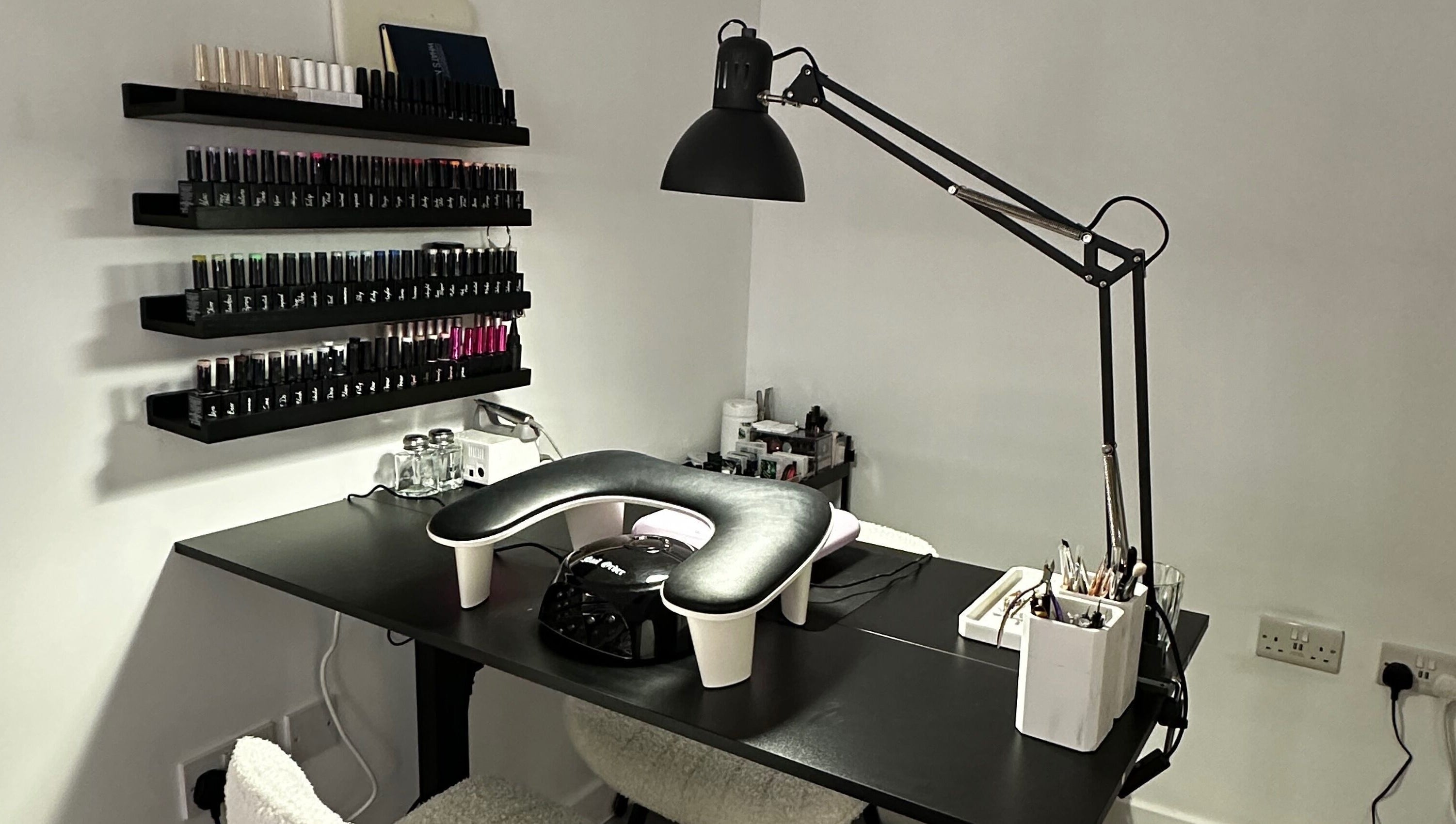 Modern nail station at Pixy Beauty in Stafford, England, GB, featuring sleek decor and organized nail polish display.