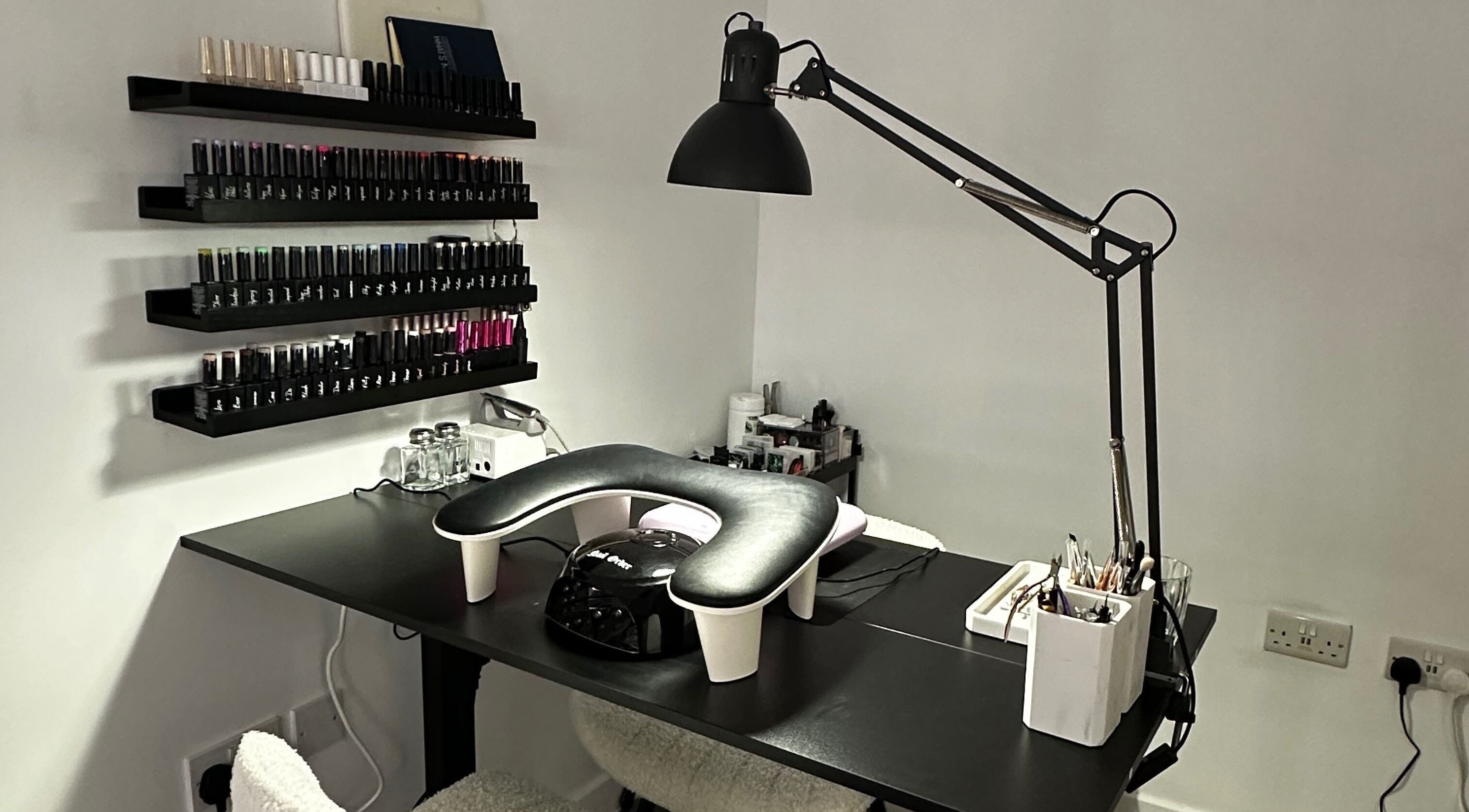 Modern nail station at Pixy Beauty in Stafford, England, GB, featuring sleek decor and organized nail polish display.