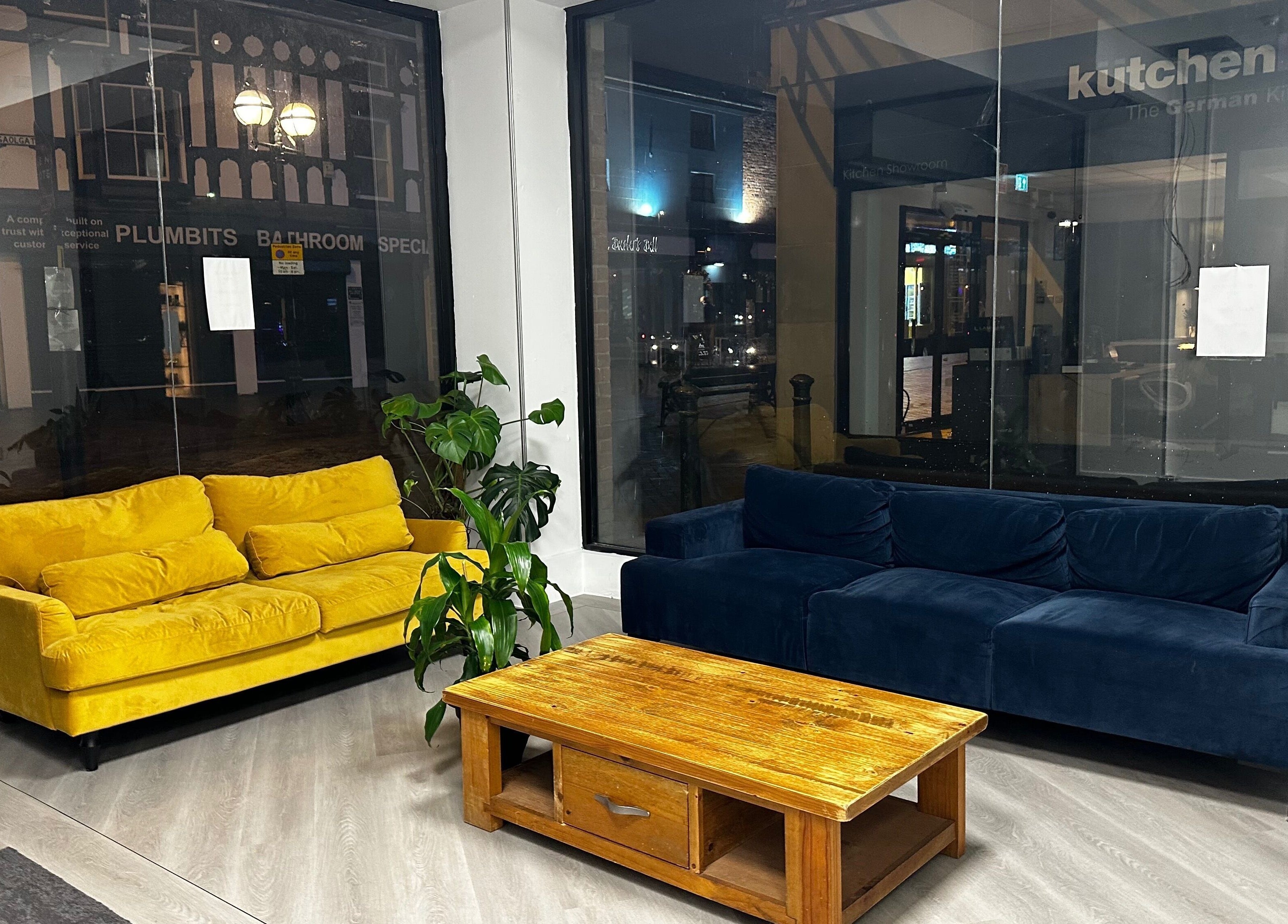 Chic lounge with yellow and blue sofas at Pixy Beauty in Stafford, England, GB showcasing modern elegance.