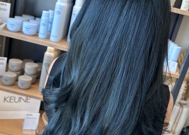 Sleek black hair styled with products at Clare Elizabeth Colour & Styling Studio, Wirral, England, GB.