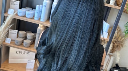Sleek black hair styled with products at Clare Elizabeth Colour & Styling Studio, Wirral, England, GB.