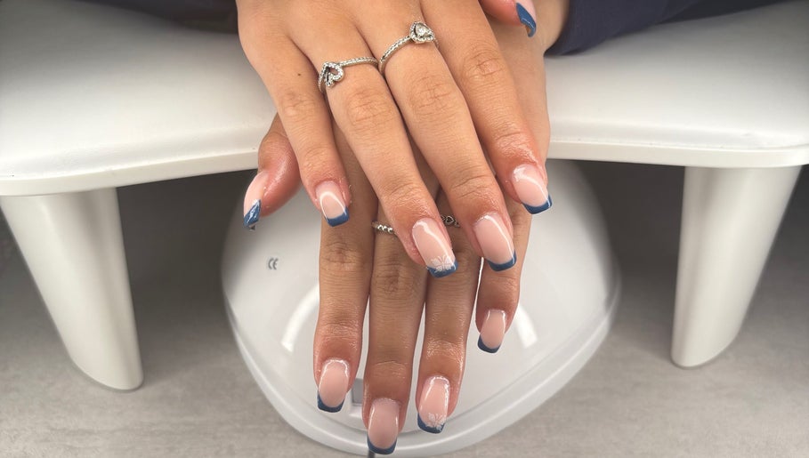 Blush beauty studio in Henfield, England, showcases elegant blue-tipped nails on a white table.