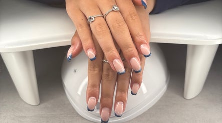 Blush beauty studio in Henfield, England, showcases elegant blue-tipped nails on a white table.