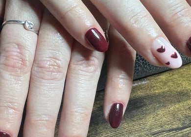 Elegant nail art with red hearts at Blush beauty studio, Henfield, England, GB.
