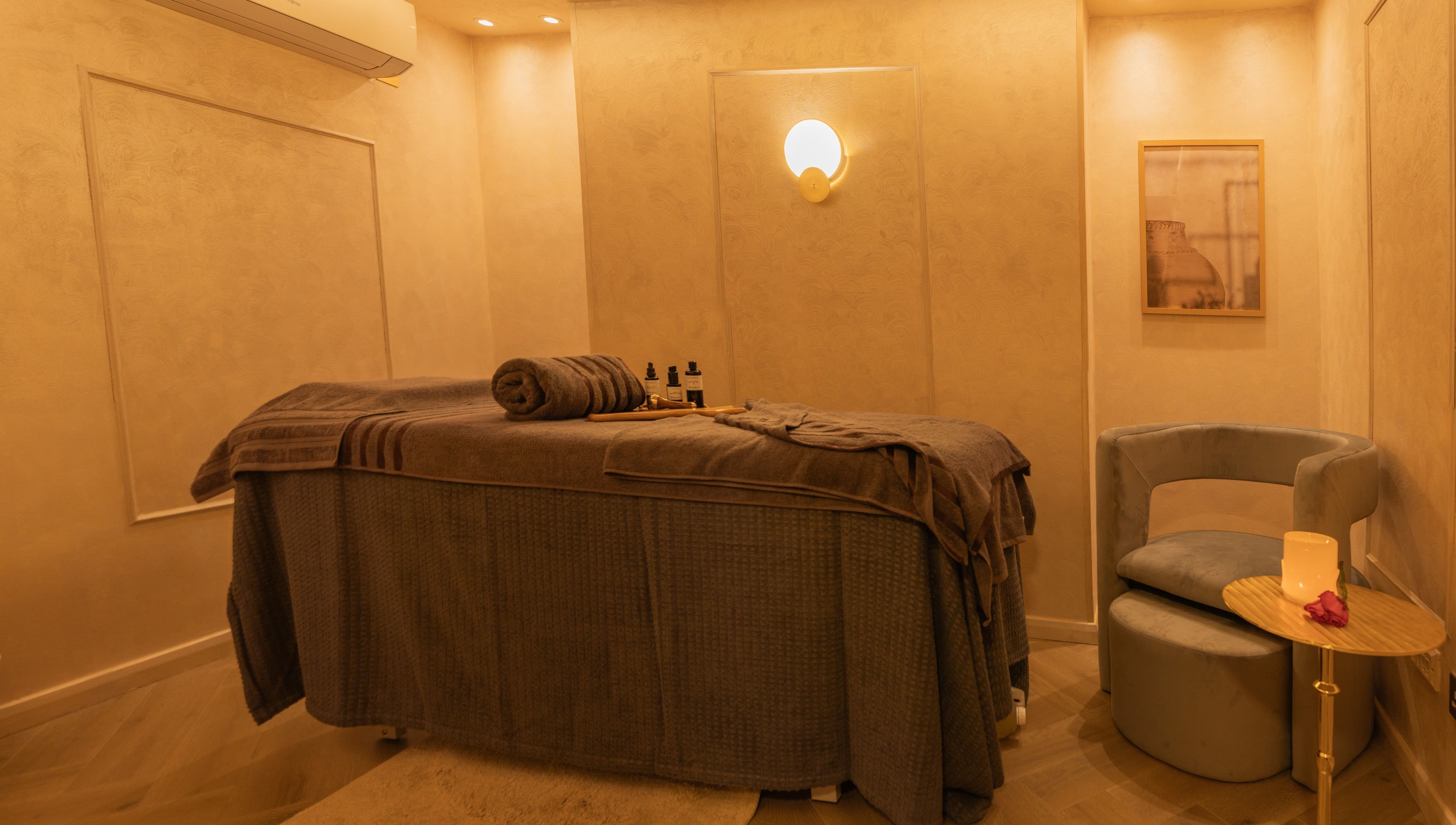 Cozy, elegant treatment room at Dimple Amani Knightsbridge, London, England, GB with a massage table and soft lighting.