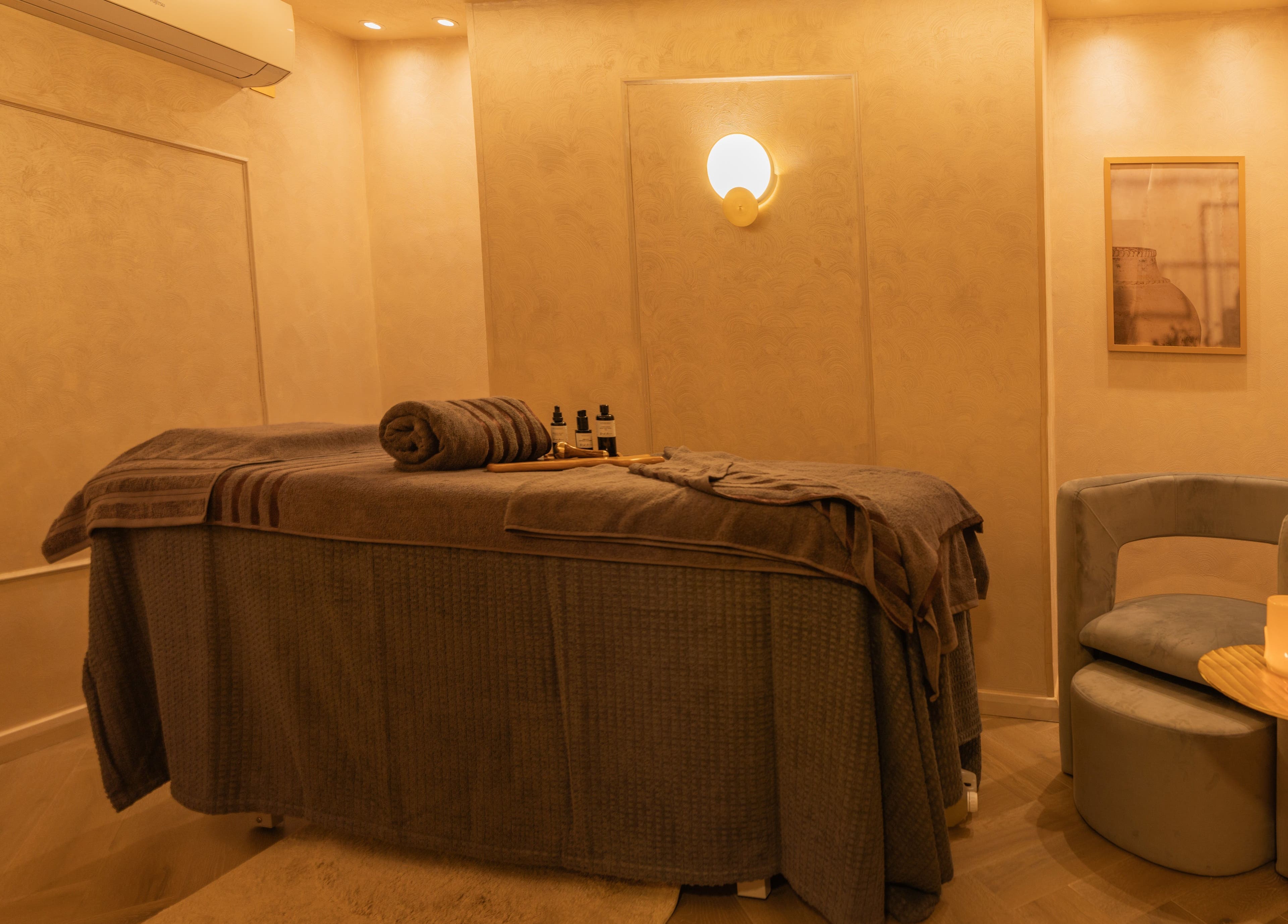 Cozy, elegant treatment room at Dimple Amani Knightsbridge, London, England, GB with a massage table and soft lighting.