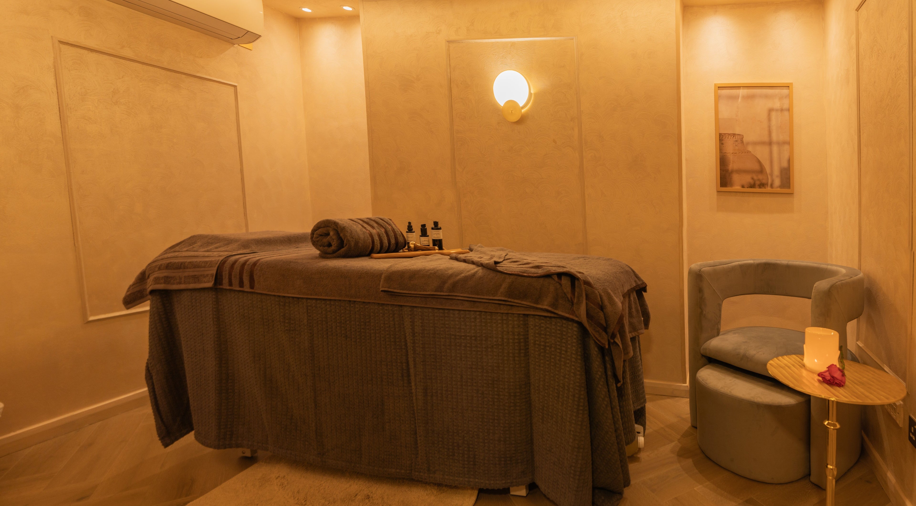 Cozy, elegant treatment room at Dimple Amani Knightsbridge, London, England, GB with a massage table and soft lighting.