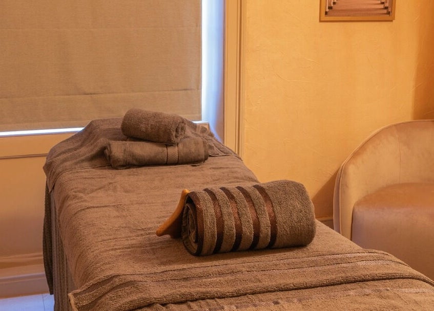 Cozy spa room at Dimple Amani Knightsbridge, London, England, GB with massage table and soft lighting.