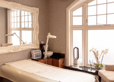 Luxurious treatment room at Mayfair Aesthetics and Beauty, London, England, GB with plush decor and large windows.