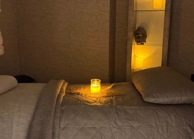 Relaxing massage room at Mayfair Aesthetics and Beauty in London, England, GB, illuminated by candlelight.