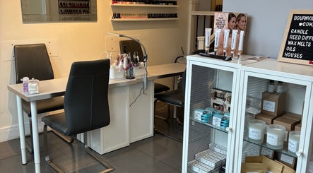 Cozy nail salon station at Beauty by Calandra, Birmingham, England, GB, showcasing beauty products and candles.