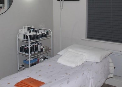 Tranquil treatment room at Therabeautic in Potters Bar, England, GB with skin care products and massage table.