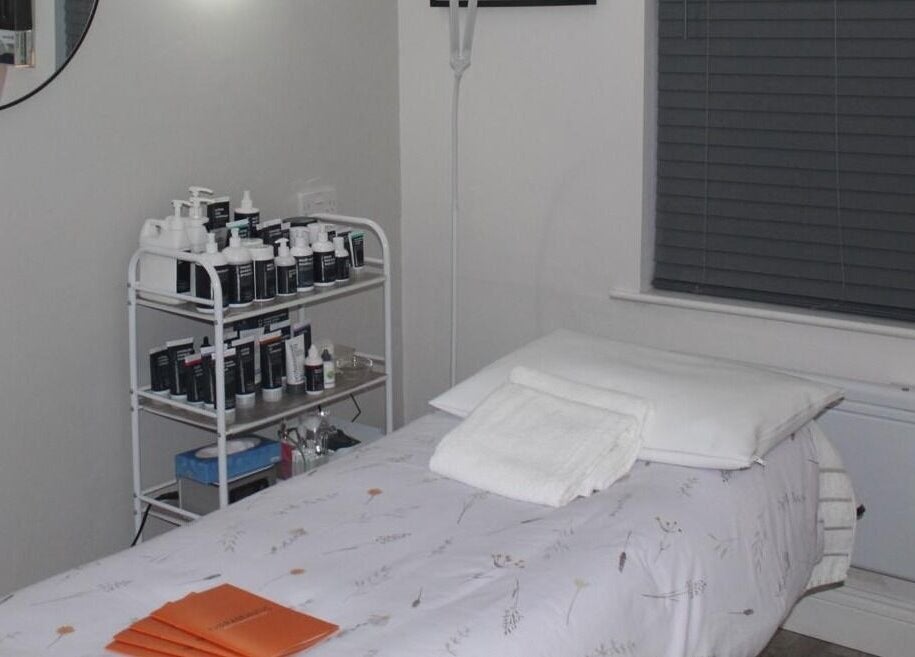 Tranquil treatment room at Therabeautic in Potters Bar, England, GB with skin care products and massage table.