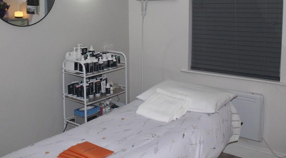 Tranquil treatment room at Therabeautic in Potters Bar, England, GB with skin care products and massage table.