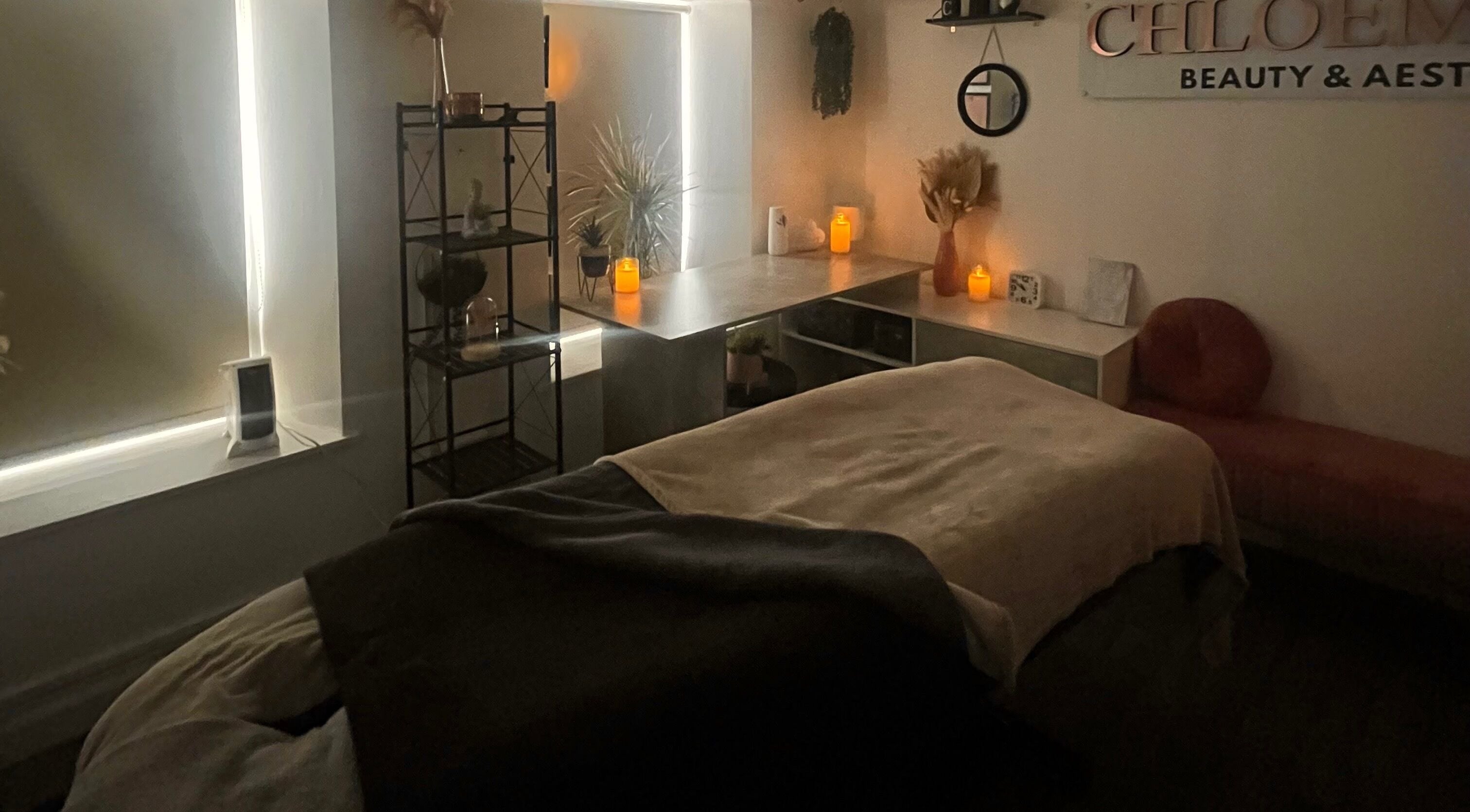 Peaceful treatment room at ChloeMarie Beauty & Wellness, Haverfordwest, Wales, GB, with soft lighting and candles.