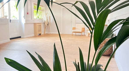Bright, peaceful room at Alma Wellbeing Barn in Bourn, England, GB with natural light and leafy plants.