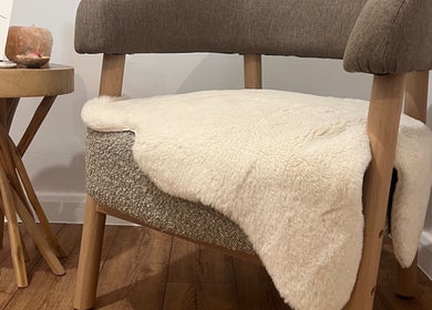 A plush chair and warm decor at Alma Wellbeing Barn, Bourn, England, GB.