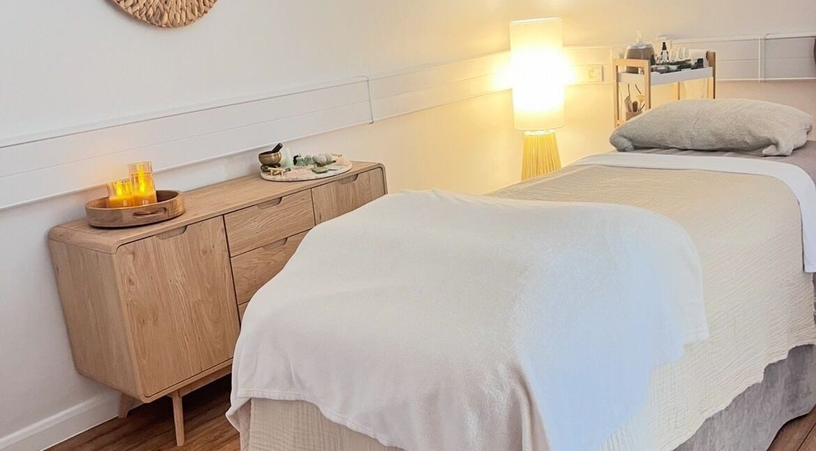 Tranquil spa room at Alma Wellbeing Barn, Bourn, England, GB. Cozy massage bed and soft ambient lighting.