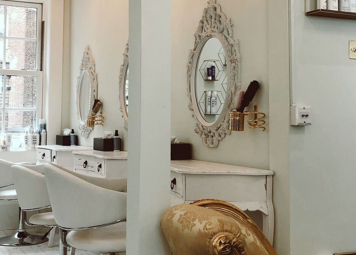 Chic interior of Jo Johnson Salon in London, England, GB with vintage mirrors and plush seating.