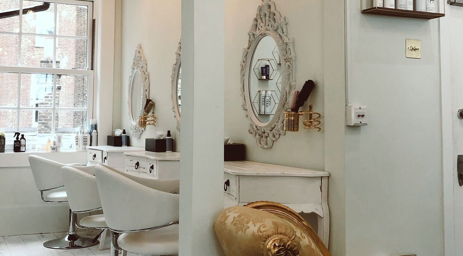 Chic interior of Jo Johnson Salon in London, England, GB with vintage mirrors and plush seating.