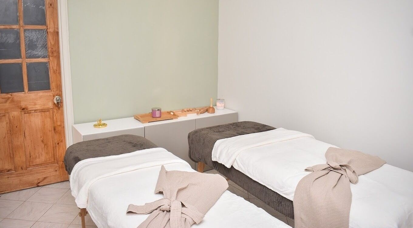 Cozy massage room at Aqua Aesthetics by Waves in Mandeville, Manchester Parish, JM, featuring two beds.