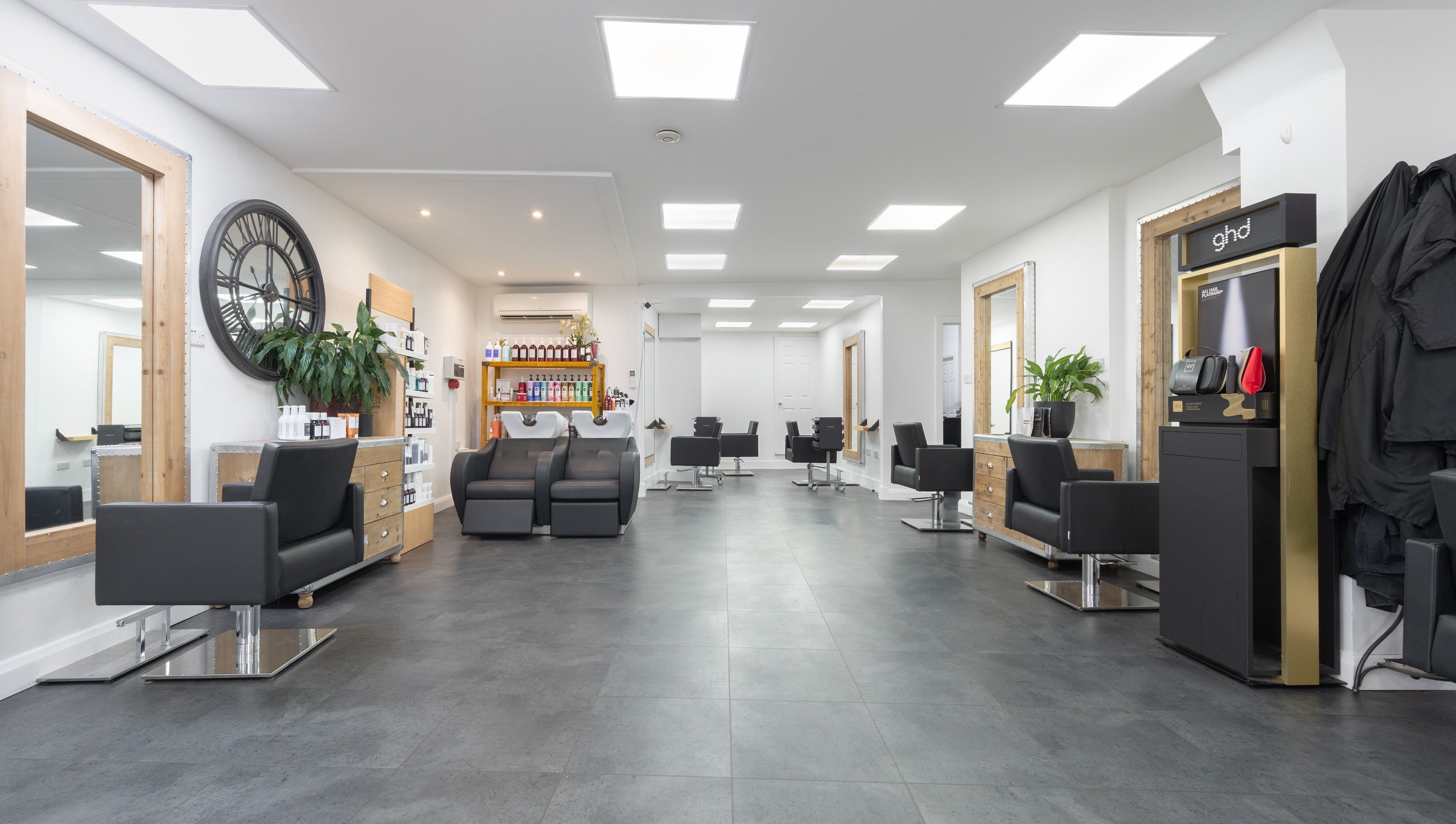 Modern interior of Cara Gibbs Hairdressing, Sale, England, GB, featuring sleek chairs and stylish decor.