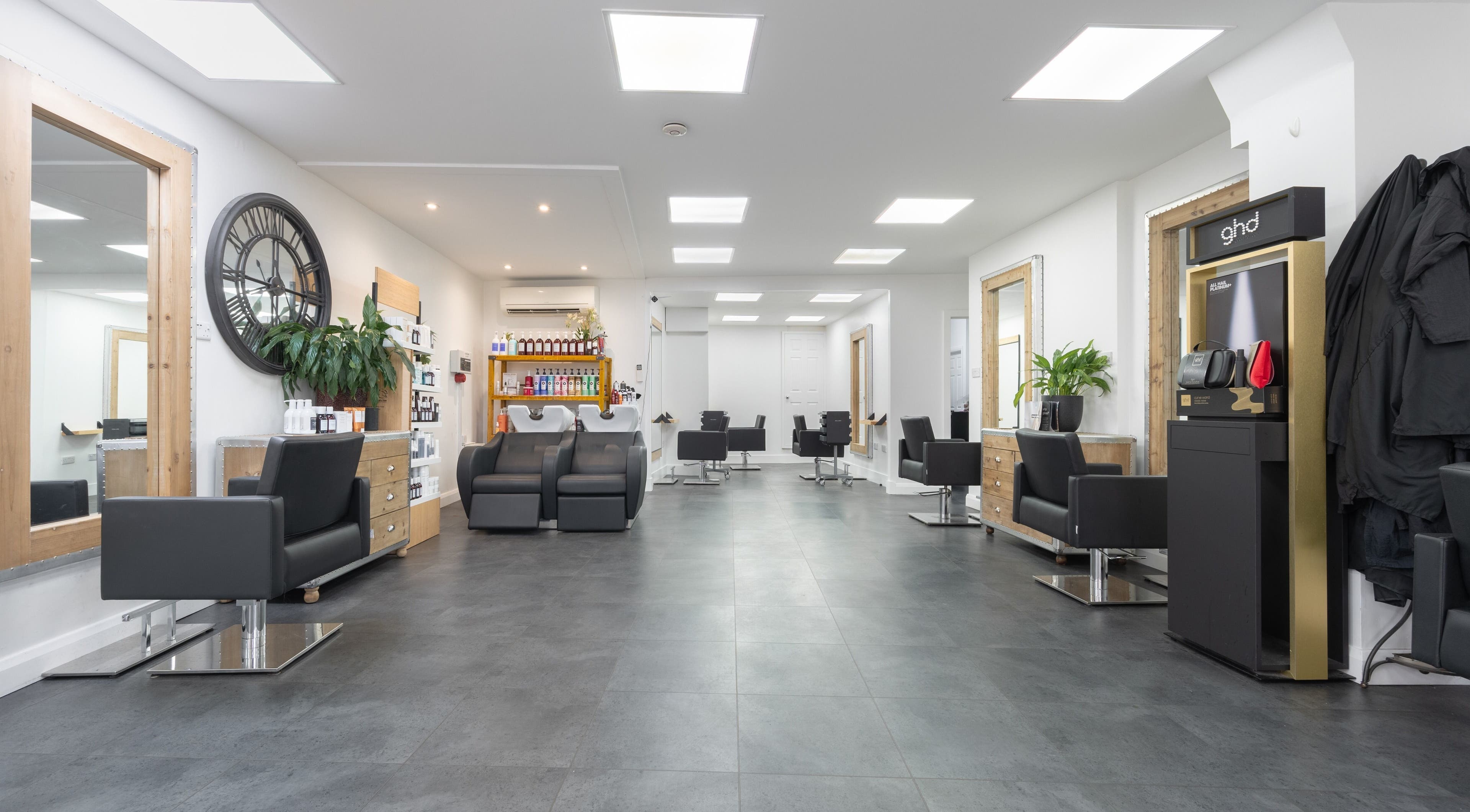 Modern interior of Cara Gibbs Hairdressing, Sale, England, GB, featuring sleek chairs and stylish decor.