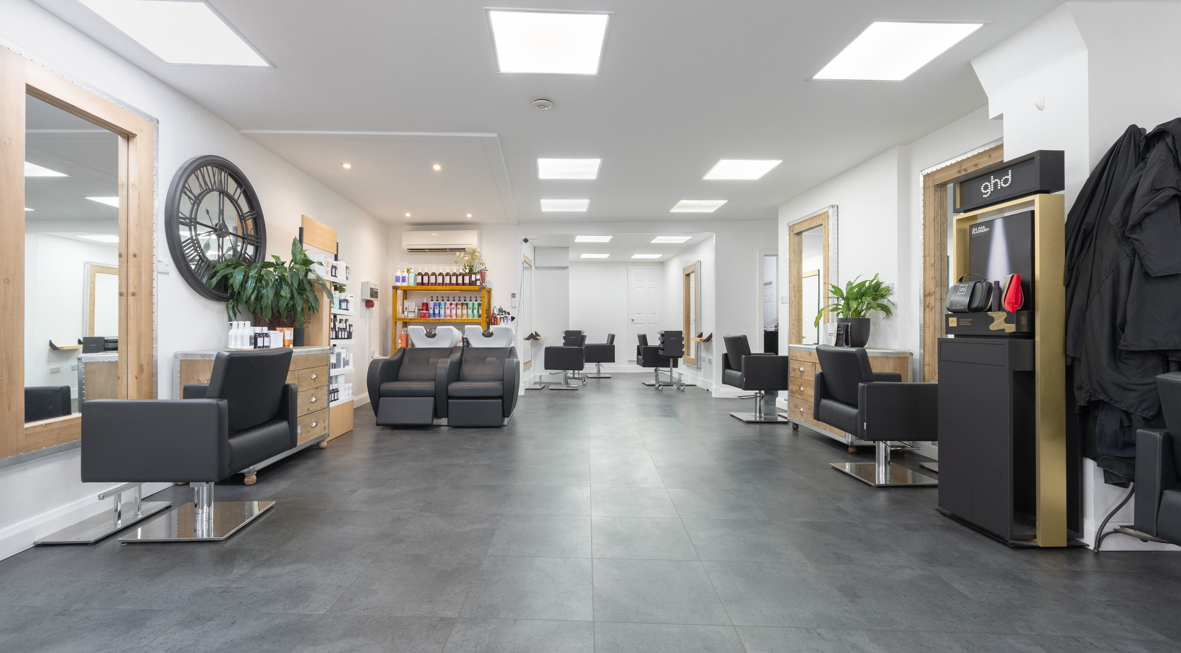Modern interior of Cara Gibbs Hairdressing, Sale, England, GB, featuring sleek chairs and stylish decor.