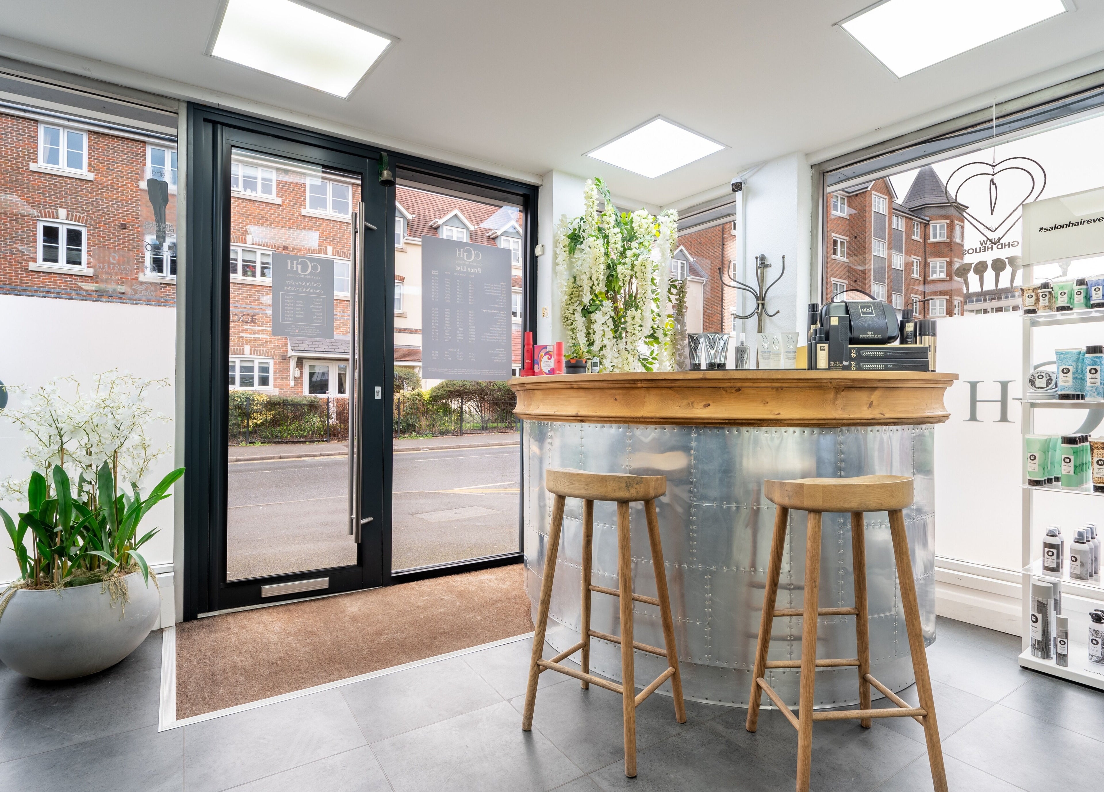 Modern entry of Cara Gibbs Hairdressing, Sale, England, GB, with stylish decor and hair product display.